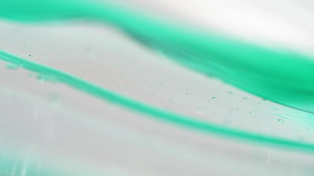 Macro Shot Of Green Cosmetic Gel Fluid Flowing On The Surface - close up