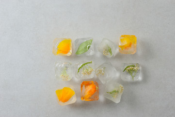 Floral ice cubes on the gray background.