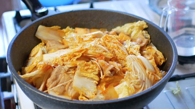 POV to the pot full of Nappa cabbage while making korean food (Kimchi Jjigae or Kimchi soup)