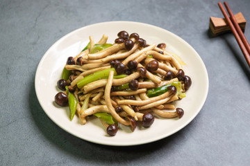 Yanagi Mutsutake (Japanese mushroom) stir-fried with oyster sauce isolated on grey table background. Healthy meal.