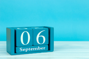 wooden calendar with the date of August 6 on a blue wooden background	
