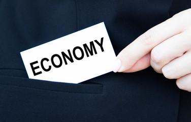 The businessman puts the look in his pocket with the inscription ECONOMY.