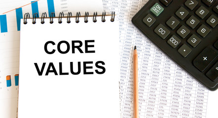 In the notebook is the inscription CORE VALUES, next to graphics, pencil and calculator.