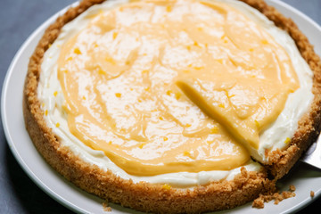 Delicious homemade honey lemon cheese pie and juicy lemon curd on plate.