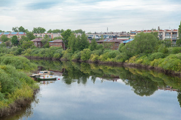 Fototapeta premium Summer russian river townscape of green embankment