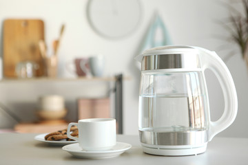 Pure water boils in an electric kettle on the table in the kitchen
