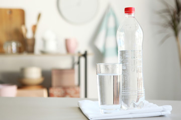 Clear water in a glass and bottle on the table