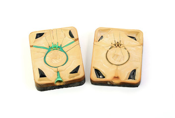 Rubber molds have green wax inside, used in the manufacture of jewelry in jewelry factories, placed on a white background.