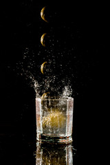 lemon falling into a glass