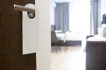 Privacy sign hanging on handle of open door to hotel room. Copy space.Nobody