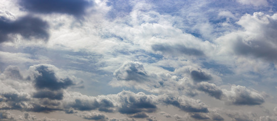 Panorama of a very cloudy blue sky, as background.