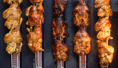 Roasted chickens on five spits in a grill