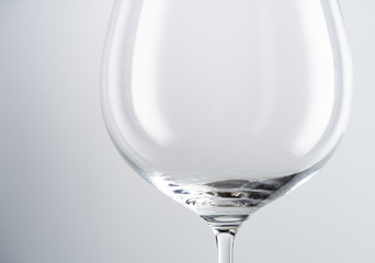 Closeup of empty transparent clean crystal goblet with slim stem placed against white background