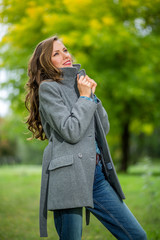 Fototapeta premium Carefree young woman in autumn park enjoying good warm weather
