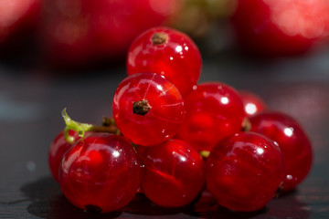 Close-up of red currant berries on a dark surface.
