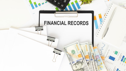 Paper with text Financial Records on a financial tables with glasses