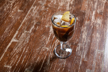 coffee with ice and lemon on a wooden table