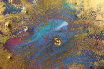 Marbled blue and pink abstract background with golden glitter.