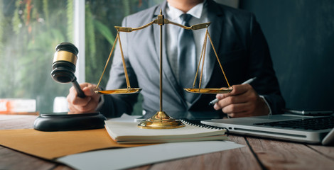 Business and lawyers discussing contract papers with brass scale on desk in office. Law, legal services, advice, justice and law concept
