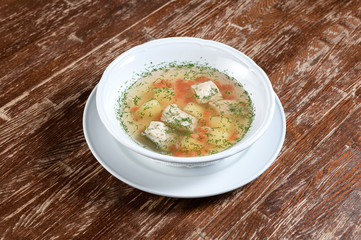 fish soup in a white plate with dill