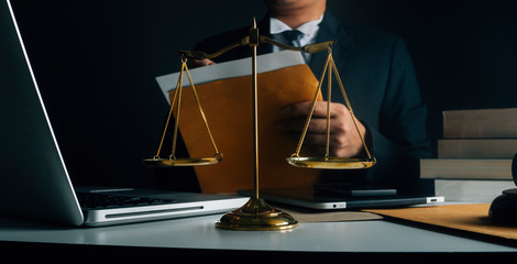 Business and lawyers discussing contract papers with brass scale on desk in office. Law, legal services, advice, justice and law concept picture with film grain effect