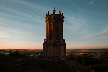 Torre del campanar de la iglesia del pueblo de Peralta, en Navarra, con un tono oscuro y los...