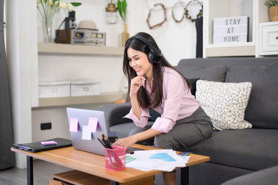A beautiful young woman wearing headset is making video conference call via computer at home , business technology concept . - Powered by Adobe