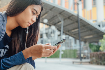 Woman playing phone park
