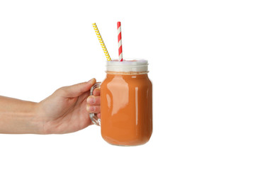 Female hand hold glass jar of pumpkin latte, isolated on white background