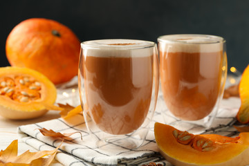 Composition with pumpkin latte on white wooden table