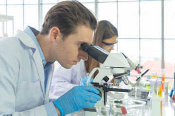 A western scientists couple working on test tube to analysis and develop vaccine of covid-19 virus...