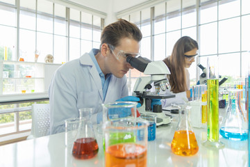 A western scientists couple working on test tube to analysis and develop vaccine of covid-19 virus...