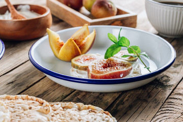 Healthy snack wholegrain rice crispbread crackers, figs and ricotta cheese on rustic wooden background.