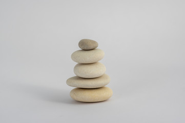One simplicity stones cairn isolated on white background, group of five white pebbles in tower