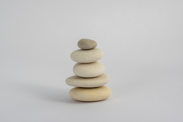 Fototapeta na wymiar One simplicity stones cairn isolated on white background, group of five white pebbles in tower