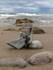 Origami paper boat stranded in a desert beach
