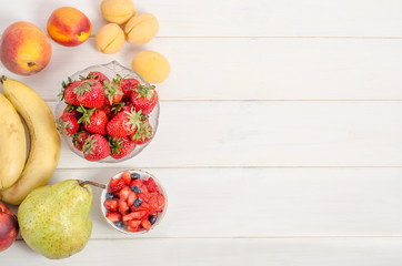 Fresh strawberries with fruits on a white background with copy space. Ingredients for fruit salad.