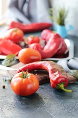 Red vegetables tomatoes and peppers, spices on the table, top view, healthy seasonal food concept, home cooking