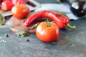 Red vegetables tomatoes and peppers, spices on the table, top view, healthy seasonal food concept, home cooking