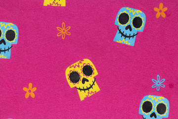 textura textil  color rosa con estampado de calaveras mexicanas de colores