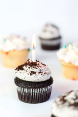 chocolate cupcake with icing and candle