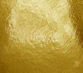 Gold foil background with highlights and uneven texture