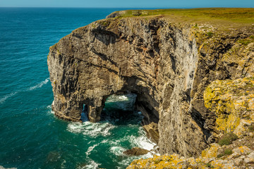 A view of an arch on the Pembrokeshire coastline seen from the Green Bridge of Wales in summer