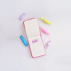Composition (mockup) with pink notepad and multicoloured markers isolated on white background