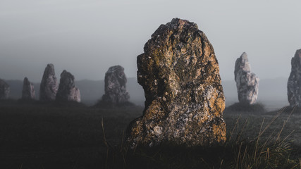 Menhir alignment view at Camaret sur mer in a mysterious morning fog at sunrise. Brittany, France....