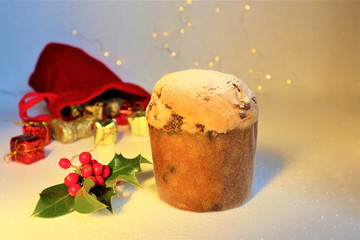 Christmas greeting card. Italian Christmas sweet (panettone) with holly branch on white background.