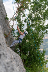 Close up of rock climber tying knot. Mountain climbing training. 
