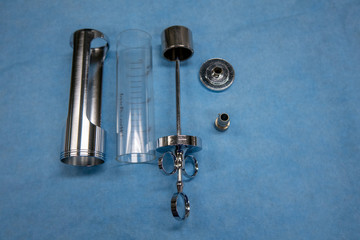  disassembled urological bladder syringe lies on a blue OP base