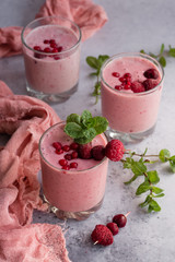 Glasses of berry smoothie on light background.