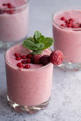 Glasses of berry smoothie on light background.